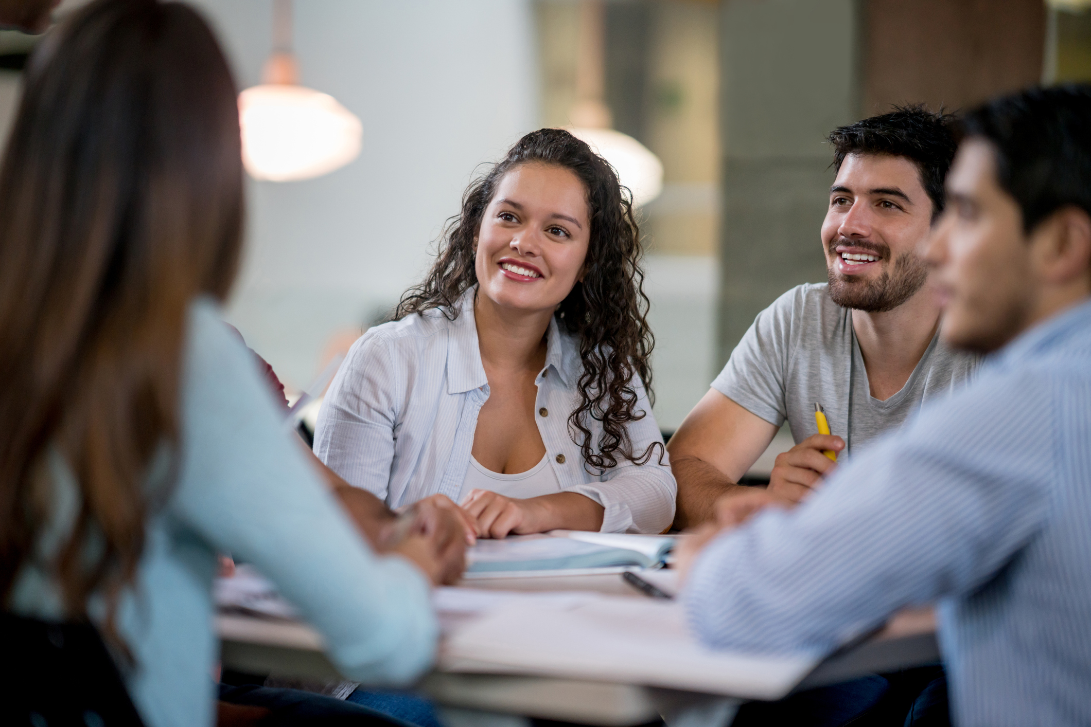 Happy young woman studying with a group of friends