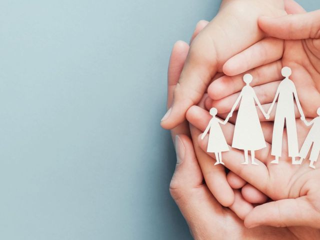 Adult and children hands holding paper family cutout, family home, foster care, homeless charity support concept, family mental health, budgeting during recession concept